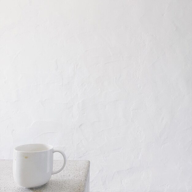 Close-up de xícara de café na mesa contra a parede