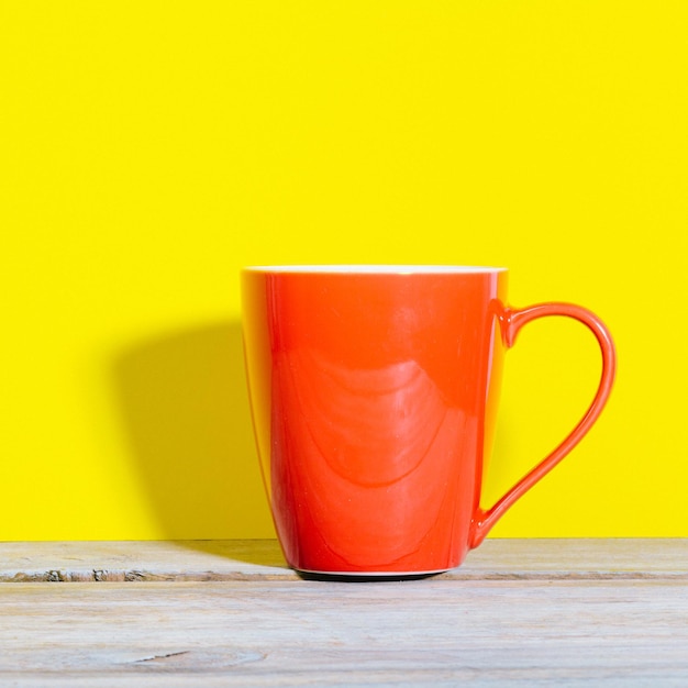 Close-up de xícara de café na mesa contra fundo amarelo