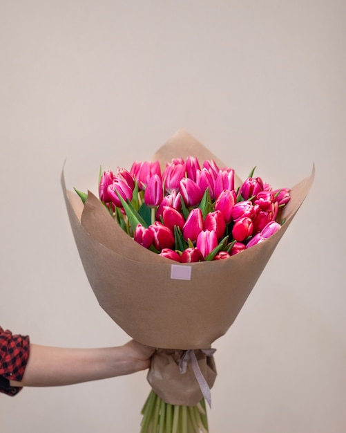 Close-up disponível segurando buquê de flores de tulipa