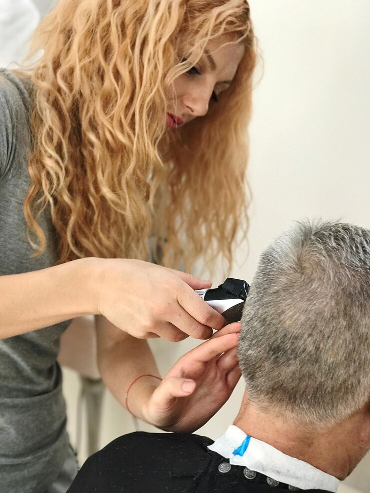 Foto close-up do barbeiro a cortar o cabelo de um homem idoso