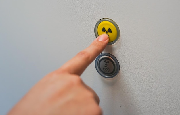 Foto close-up do botão do símbolo de aviso radioativo pressionado à mão