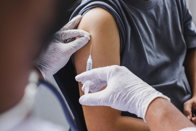 Close-up do braço do paciente que está sendo injetado com vacina ou anticorpos em seu braço