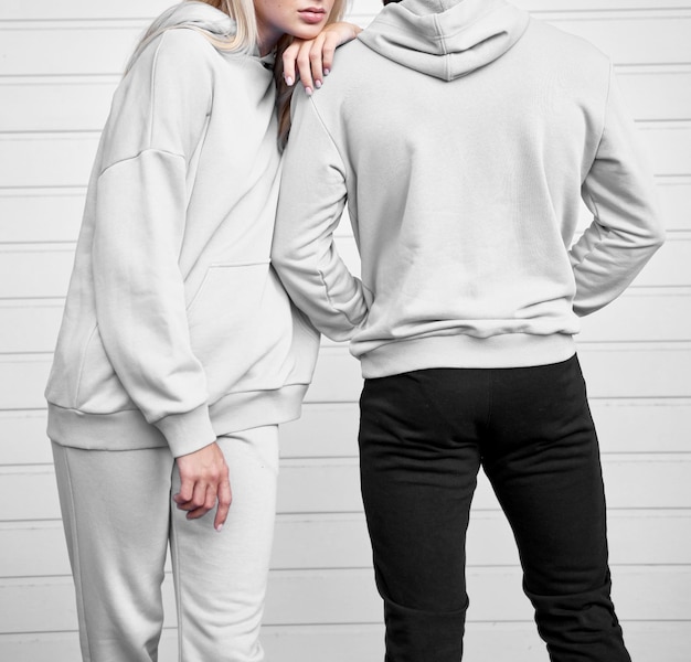 Close-up do capuz em uma menina Par de mulher e homem estão de pé em jumper com capuz Marca e modelo de maquete de design Close-up de tecido têxtil