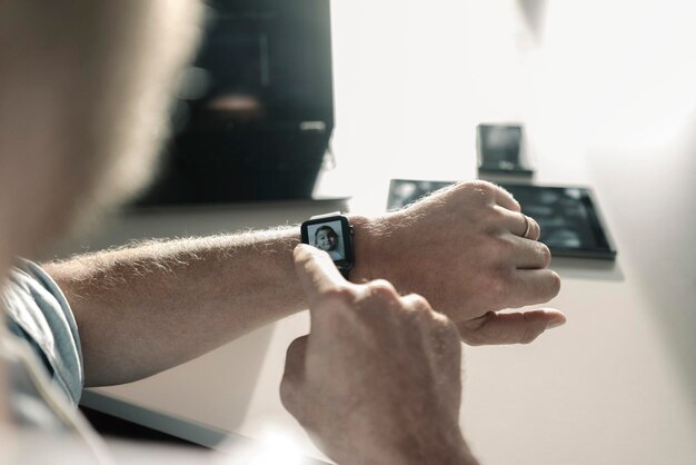 Close-up do empresário com smartwatch mostrando a imagem de uma garota