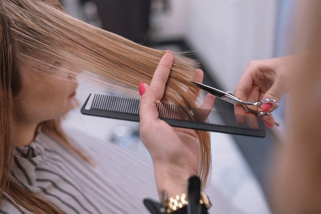 Foto close-up do estilista que corta o cabelo acaba