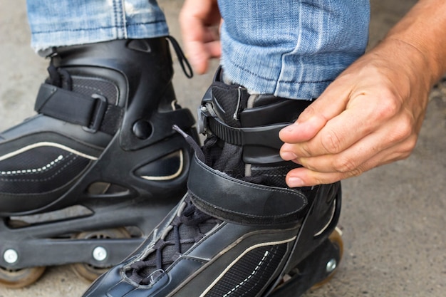 Close up do homem cara colocando patins ao ar livre