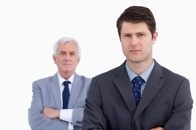 Close-up do homem de negócios sério com seu mentor atrás dele