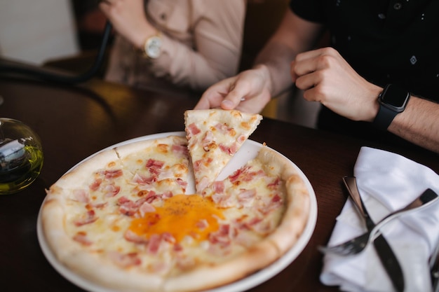 Close-up do homem pegando uma fatia de pizza no restaurante