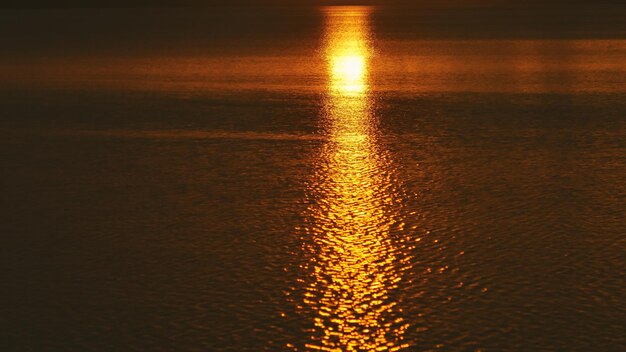 Foto close-up do mar iluminado contra o céu ao pôr-do-sol