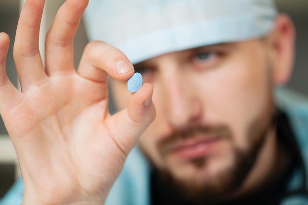 Close-up do médico masculino segurando a pílula para a saúde dos homens.