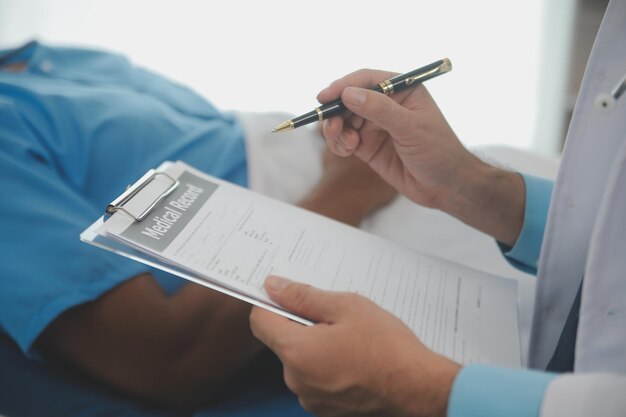 Foto close-up do médico sentado ao lado da cama de um paciente do sexo masculino no hospital