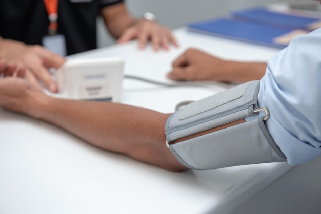 Foto close-up do medidor de pressão arterial no braço do paciente no hospital