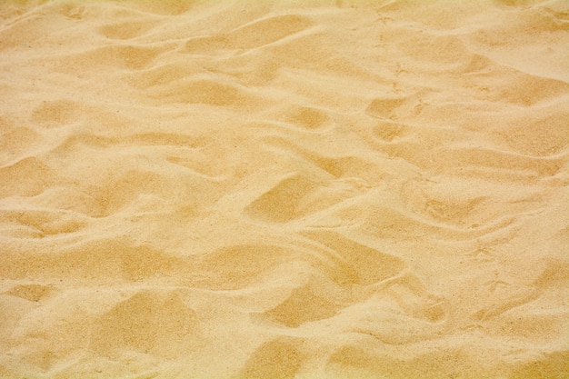 Close up do padrão de areia de uma praia no verão