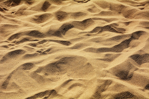 Close up do padrão de areia de uma praia no verão