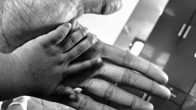 Foto close-up do pai segurando a mão do bebê
