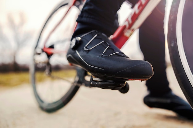 Close-up do pé de um esportista no pedal enquanto ele faz uma pausa