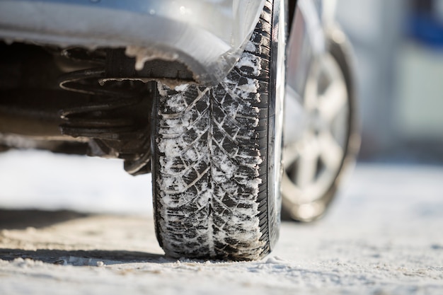Close-up do pneu de borracha das rodas de carro na neve profunda.