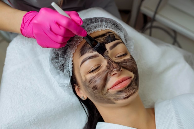 Foto close-up do procedimento de peeling de carbono para mulher de meia-idade rosto pulsos de laser limpar a pele processo de