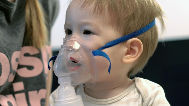 Close-up do próprio bebê usando máscara de nebulizador de inalador de vapor