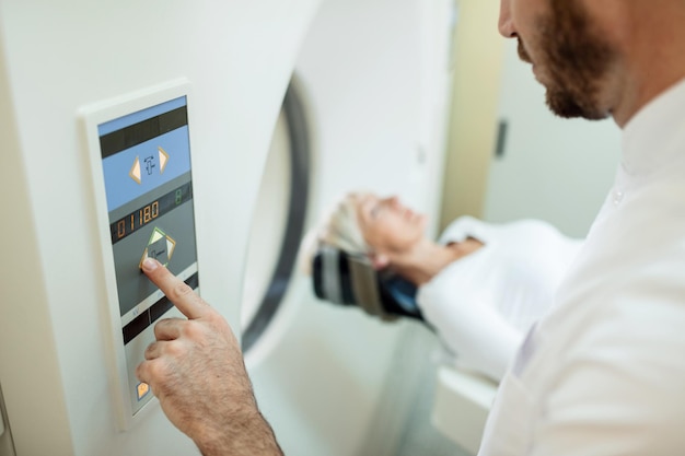 Close-up do radiologista iniciando o exame de tomografia computadorizada de um paciente no hospital