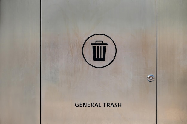 Close-up do recipiente de lixo de aço inoxidável moderno com sinal de lata e lixo de inscrição