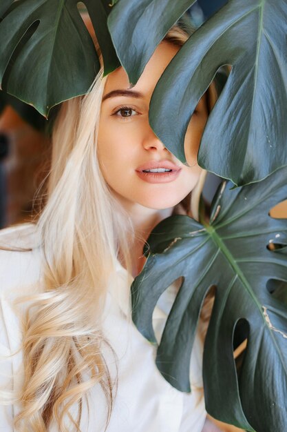 Foto close-up do rosto de menina bonita em todos os lugares deixa planta de casa verde