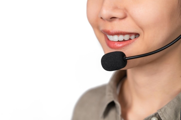 Foto close-up do rosto sorridente usando fone de ouvido é operadora de telefone de suporte ao cliente central de atendimento de serviço de consultoria em fundo cinza