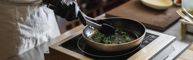 Close-up do trabalhador da cozinha está fritando verduras para cozinhar o prato principal no restaurante