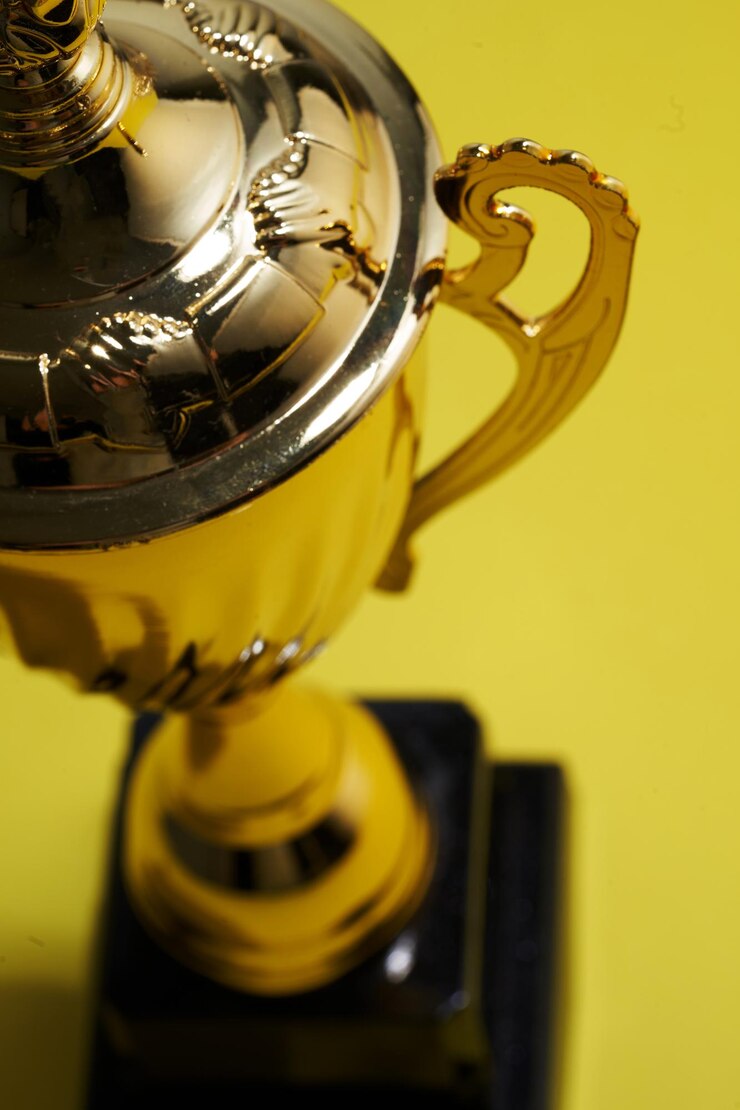 Foto close-up do troféu em fundo amarelo