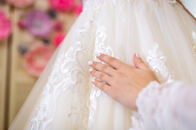 Close-up do vestido de noiva branco Noiva com as mãos no lindo vestido de noiva branco