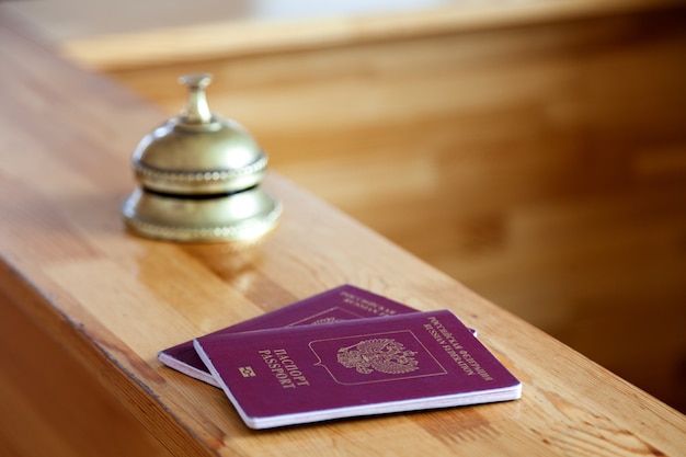 Close-up dois passaportes russos na mesa de recepção de madeira