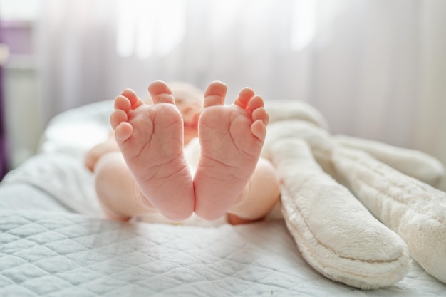 Close-up dos pés do bebê recém-nascido deitado no cobertor em casa