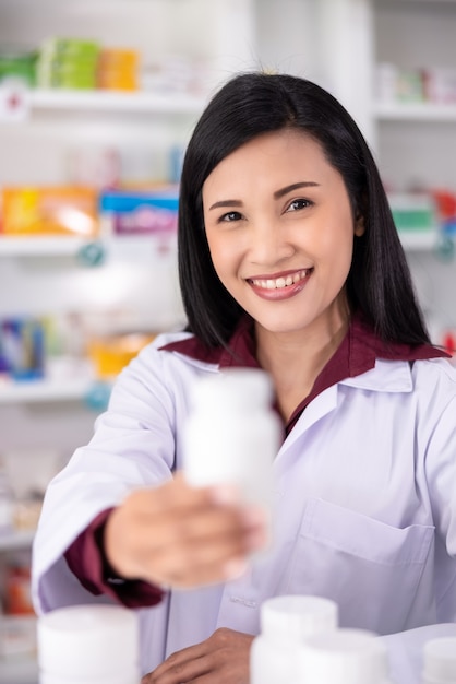 Close-up e foco seletivo no olho farmacêutico feminino asiático mostrar remédio em farmácia '