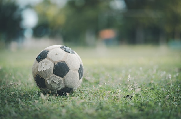 Foto close-up eines alten fußballs auf dem alten fußballfeld