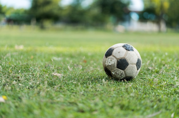 Foto close-up eines alten fußballs auf dem alten fußballfeld