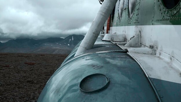 Close-up eines alten, rostigen Flugzeugs auf einem Hügel mit äußeren Details von Flugzeugen mit schweren Wolken und