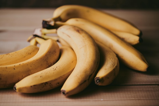 Close-up eines Bündels Bananen auf einem hölzernen Küchentischhintergrund