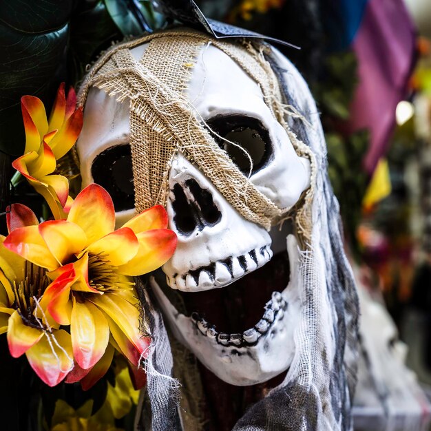 Foto close-up eines mit blumen geschmückten gruseligen schädels während einer halloween-party halloween-party und angstkonzept