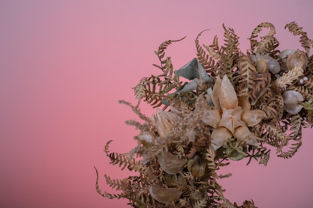 Close-up eines Viertels eines Kranzes aus getrockneten Blumen mit Physalis auf dem lila Hintergrund