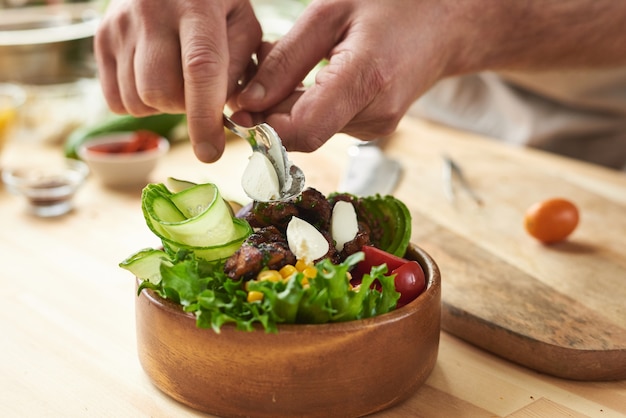 Foto close-up de elegante cuenco de madera con verduras frescas y carne preparada por el chef