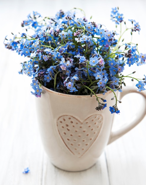 Close-up em Forget-me-not flowers in a cup