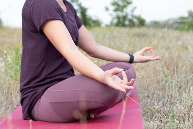 Close-up em jovem meditando no campo