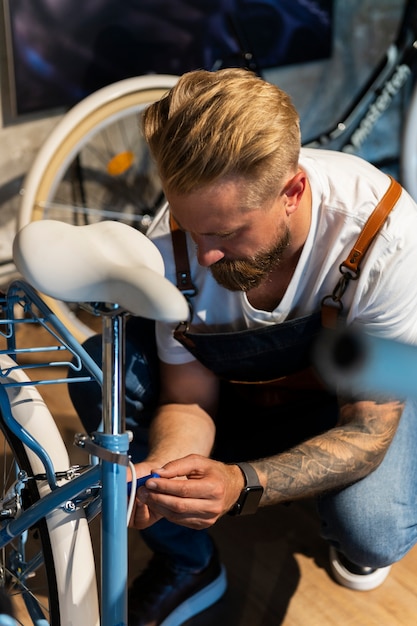 Foto close-up em jovem trabalhando em uma bicicleta