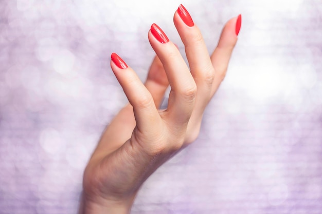 Close-up em lindas mãos femininas com manicure Red Nail Art.