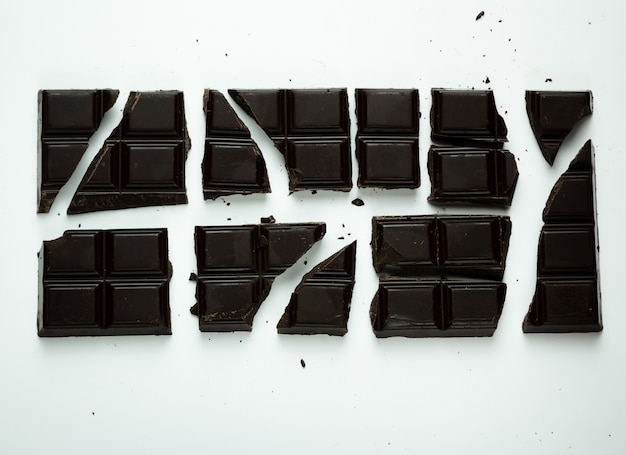 Foto close-up em pedaços de chocolate preto isolado