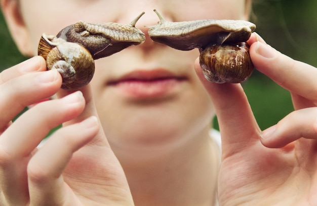 Close-up em uma jovem segurando caracóis nas mãos