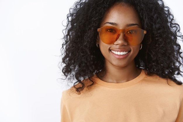 Close-up encantadora mujer joven de piel oscura con impresionantes gafas de sol de moda