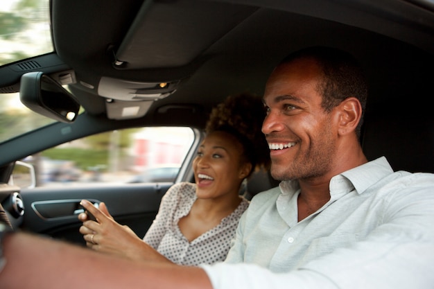 Close-up feliz casal americano africano em carro rápido sorrindo