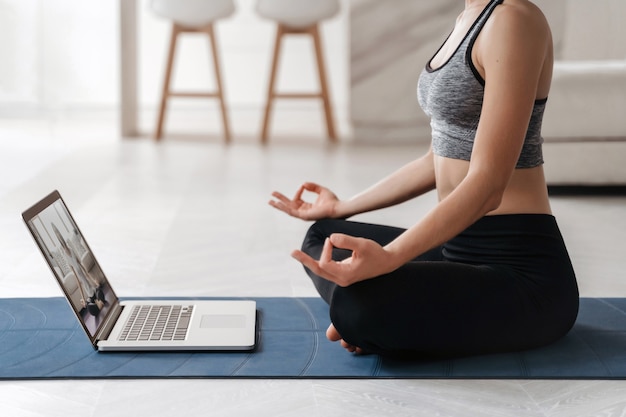 Close up fit Frau Coach hat Internet-Video Online-Training von Hatha Yoga, Sukhasana Haltung üben