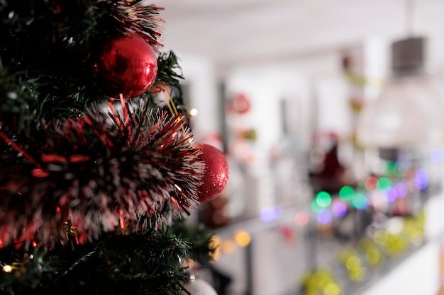 Close-up-Fokus auf Weihnachtsbaum in Rot geschmückt mit modernem Büro verschwommen im Hintergrund.